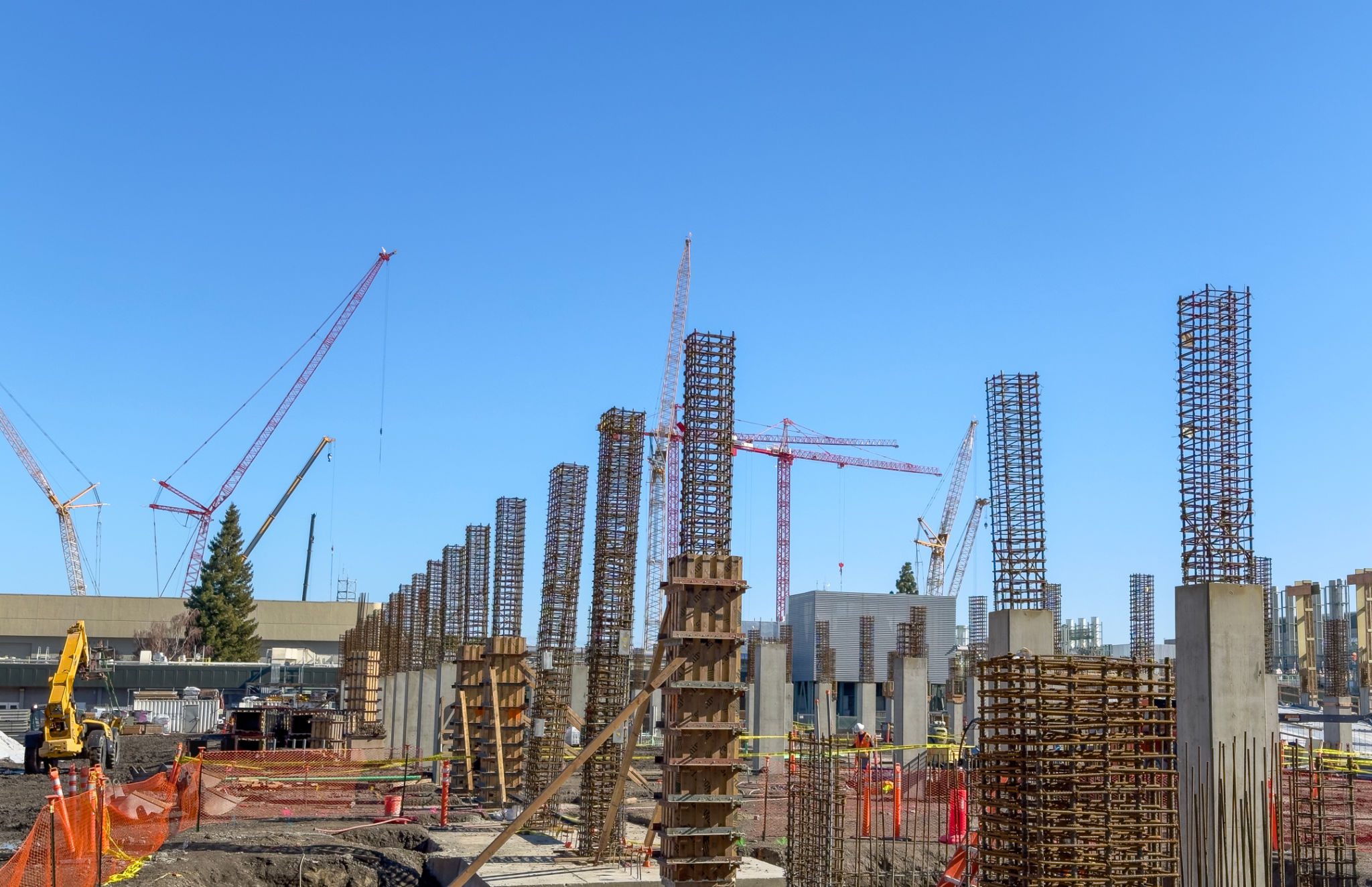 Construction site with cranes and building framework.