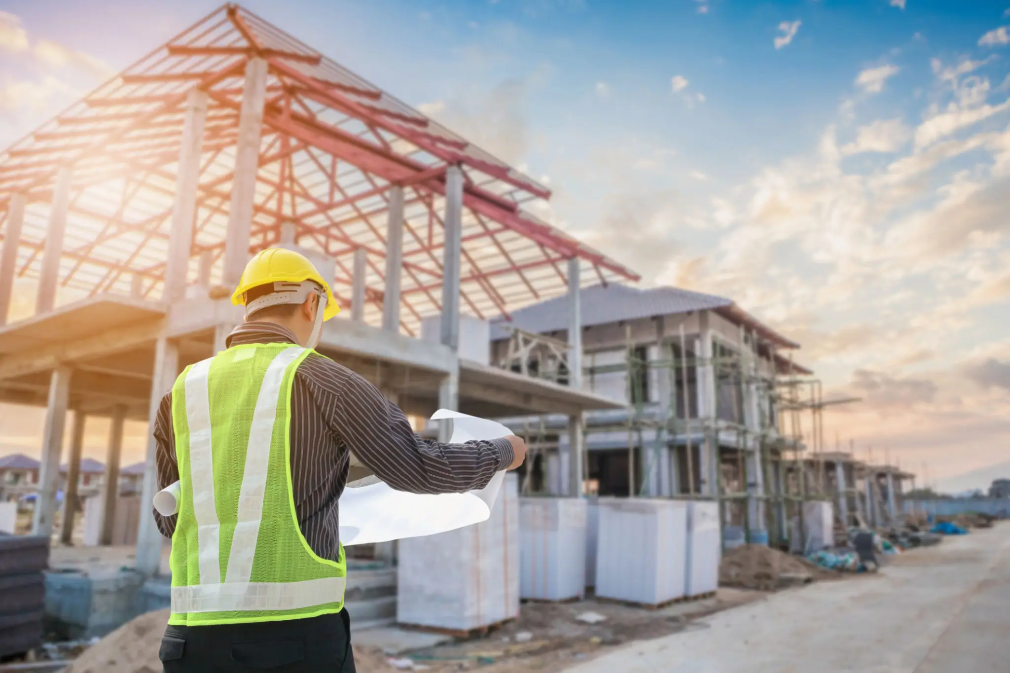 Construction worker reviewing building plans at a construction site.